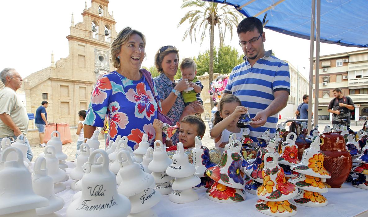 Varias personas disfrutan de las tradicionales campanitas de barro de la Velá de la Fuensanta