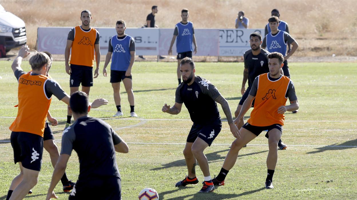 Víctor Mena, de naranja, defiende una acción durante un entrenamiento