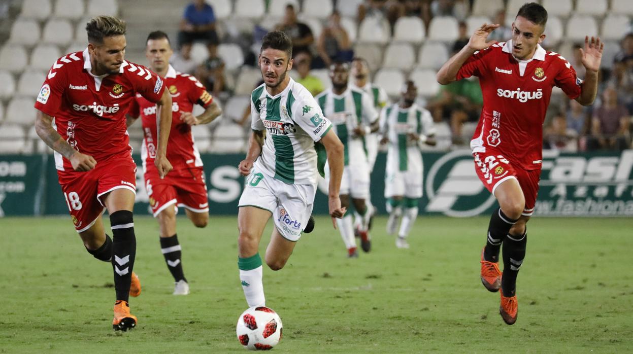 Andrés Martín avanza con el esférico entre Cadamuro y Pol, jugadores del Nástic de Tarragona