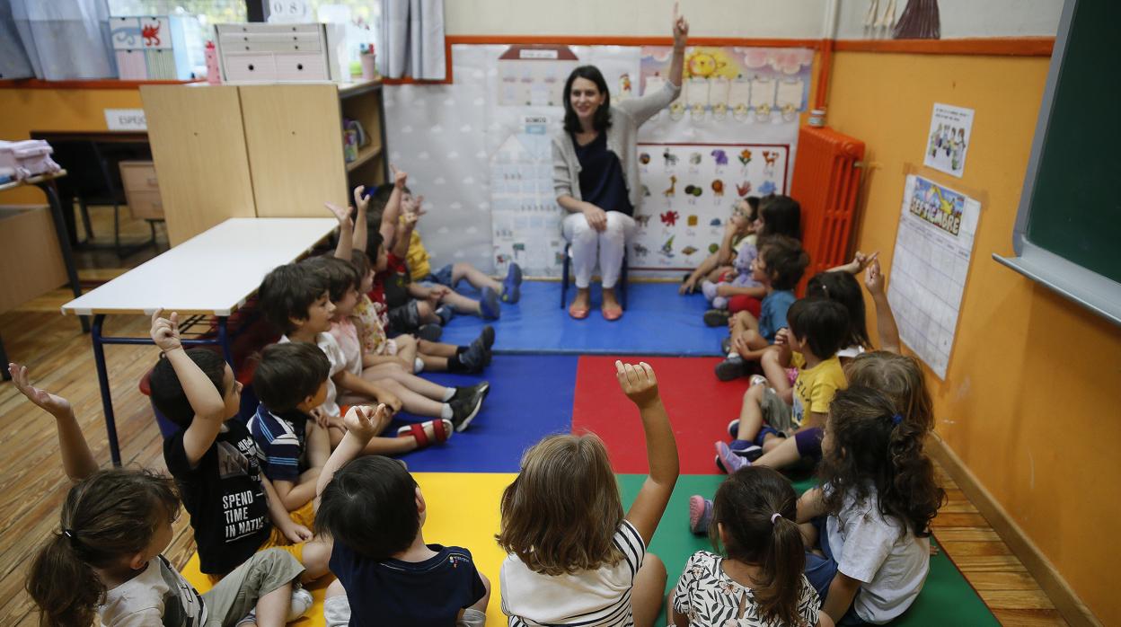 Una profesora delante de unos alumnos de corta edad