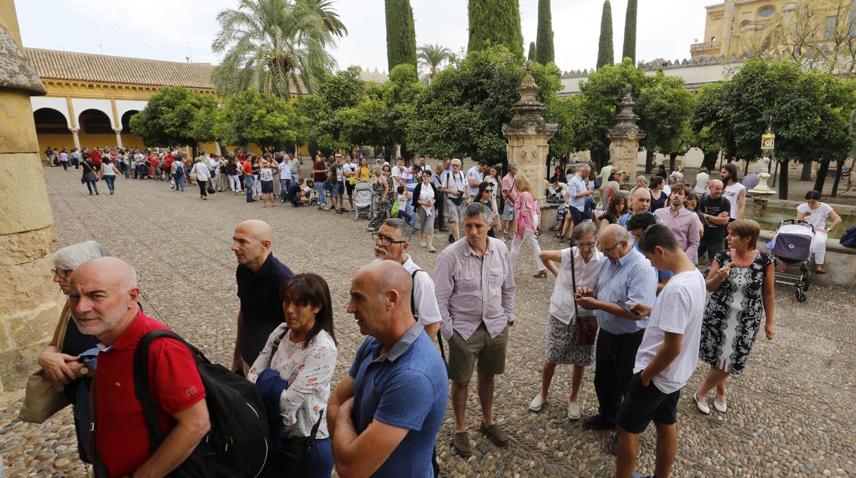 Turistas hacen cola para comprar entradas en el Patio de los Naranjos de la Mezquita-Catedral de Córdoba