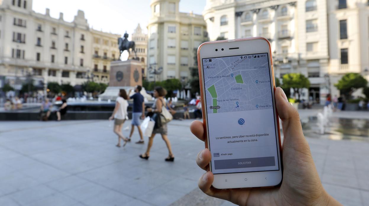 Un usuario muestra la aplicación de Uber en la plaza de Las Tendillas de Córdoba