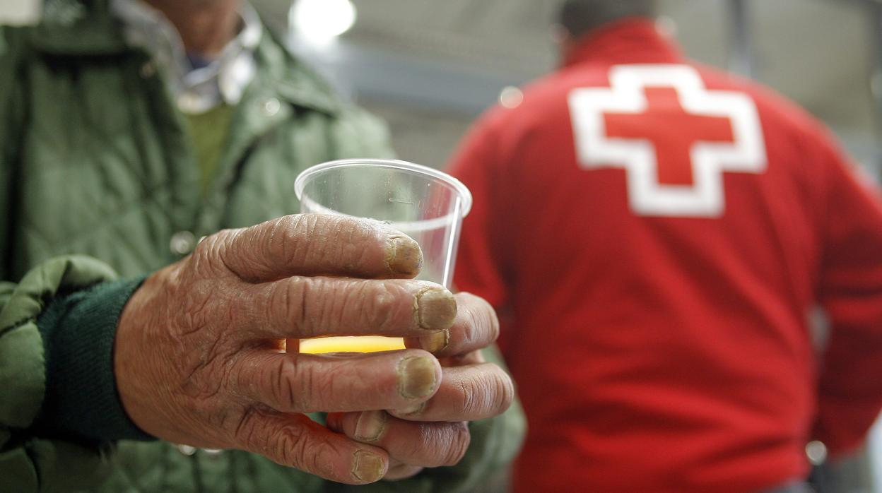 Un hombre recibe alimentos de la Cruz Roja