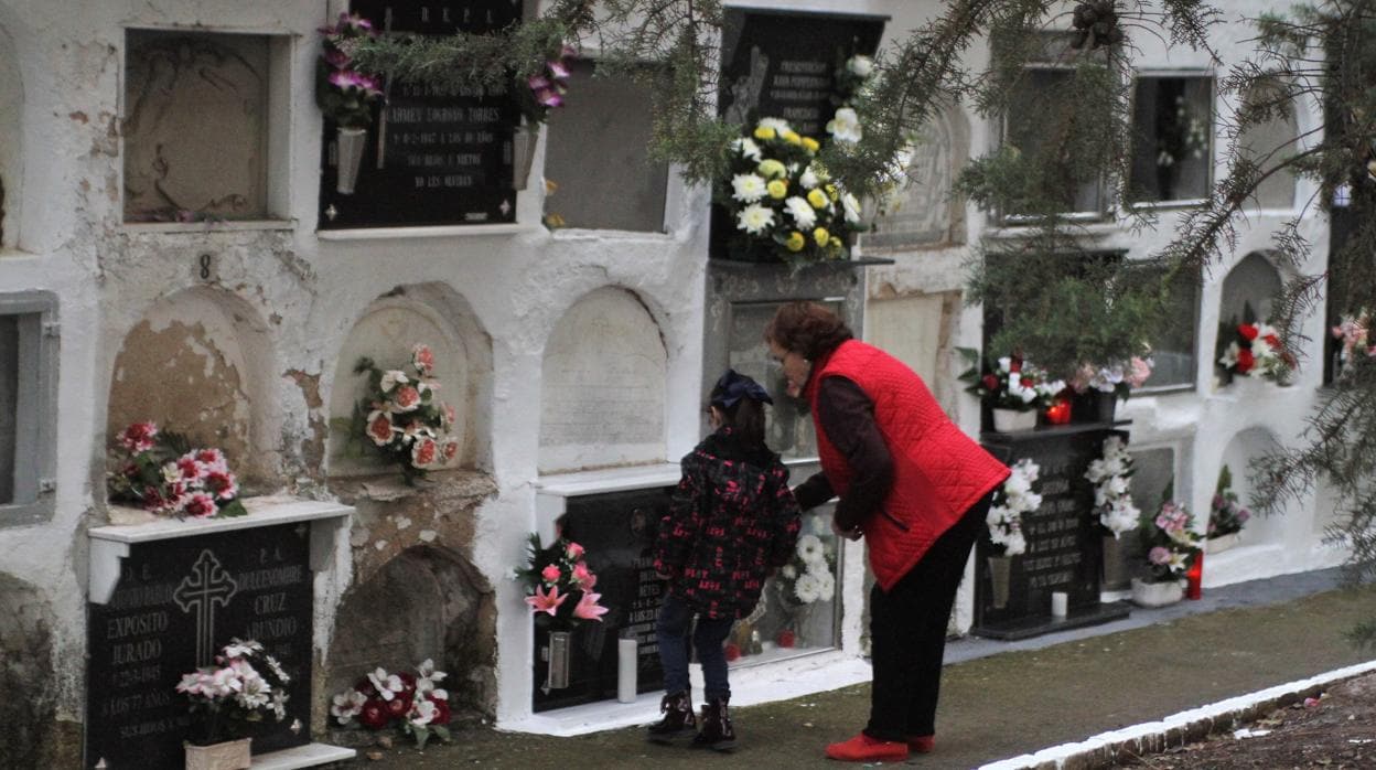 Una mujer con su nieta en el cementerio de San Rafael de Monturque
