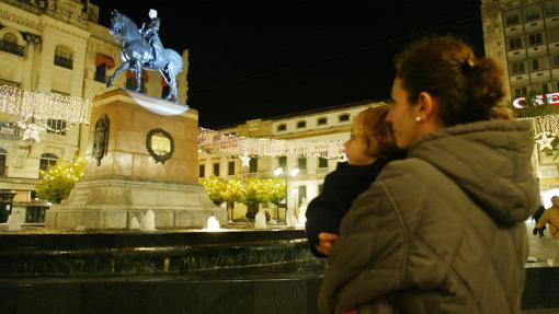 Una madre con su hija mira la estatua del Gran Capitán de Córdoba