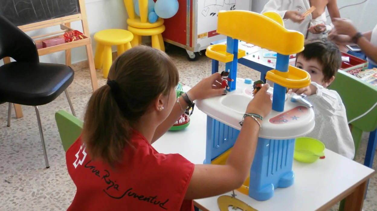 Una voluntaria juega con uno de los niños hospitalizados