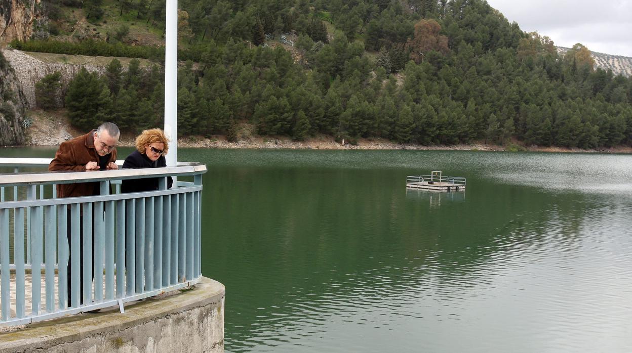 Una pareja observa el nivel del agua del pantano de Iznájar