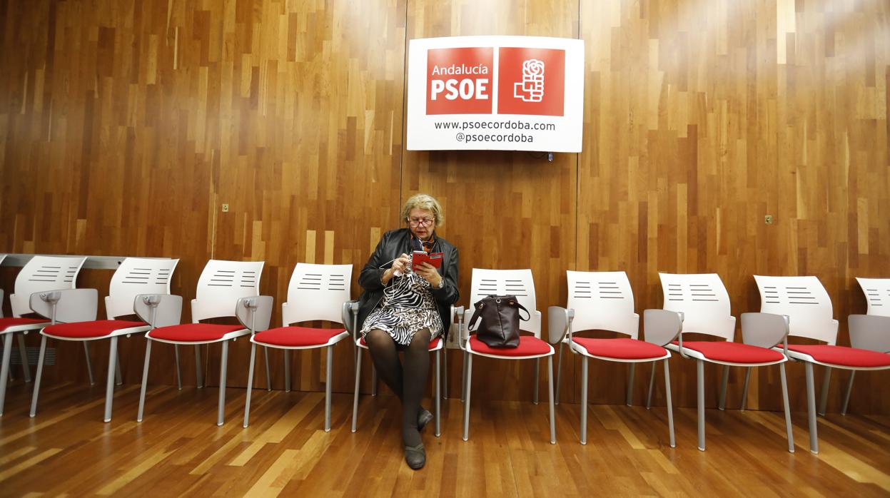 Una mujer consulta su móvil en la sede del PSOE de Córdoba