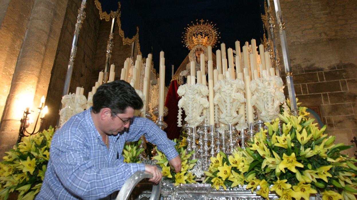 Rafael Carmona coloca las flores al palio de Nuestra Señora de la Palma en el año 2004