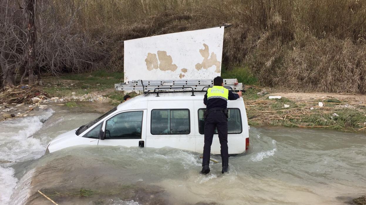 Un policía local participa en el rescate de un vehículo en Cabra