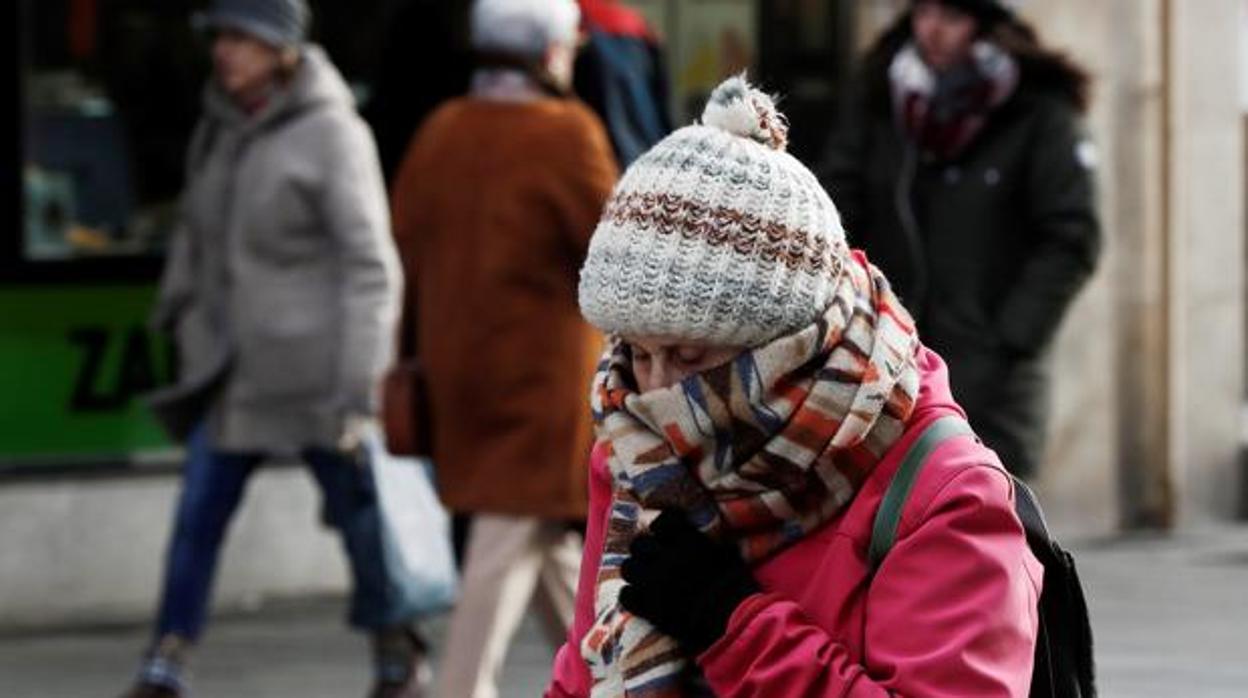 Una mujer se protege del frío con bufanda y gorro