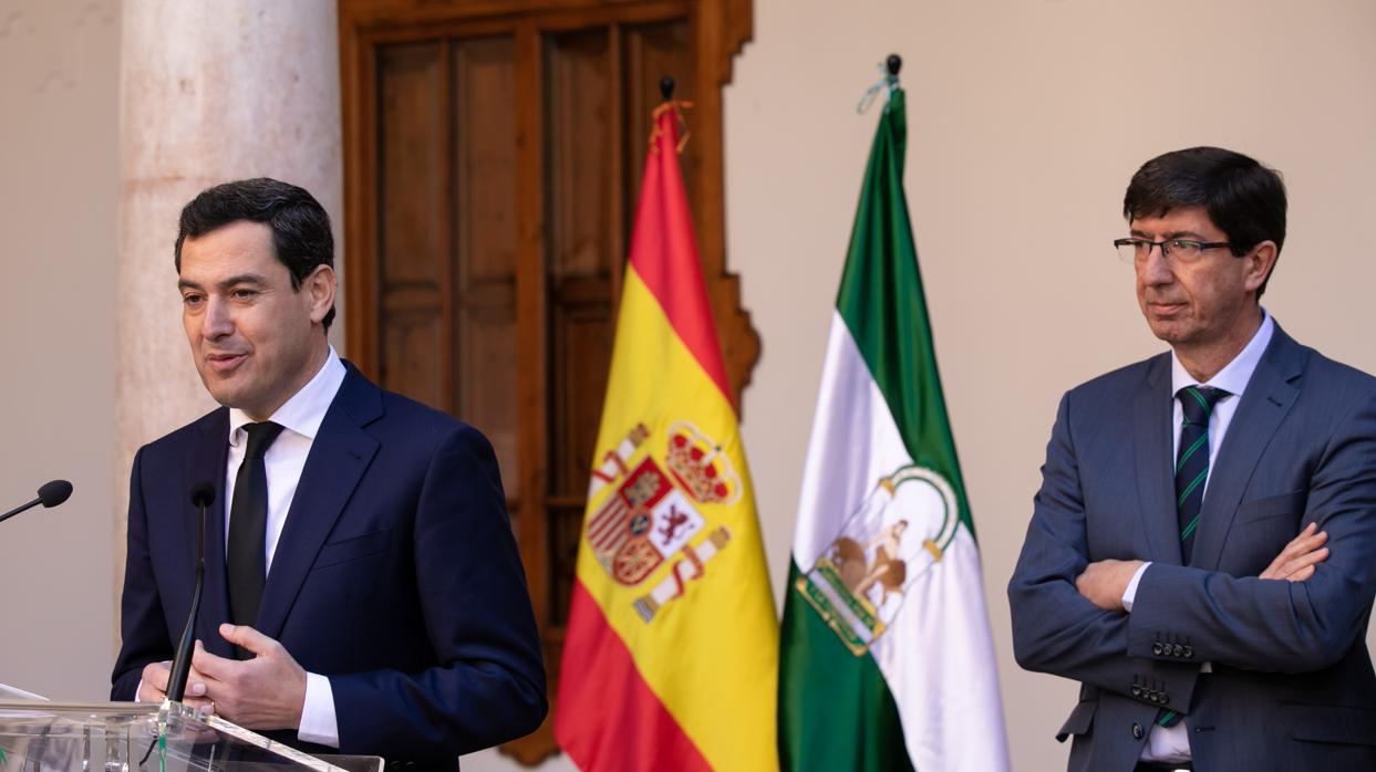 El presidente de la Junta, Juanma Moreno, habla ante los medios bajo la mirada de Juan Marín este sábado en Antequera