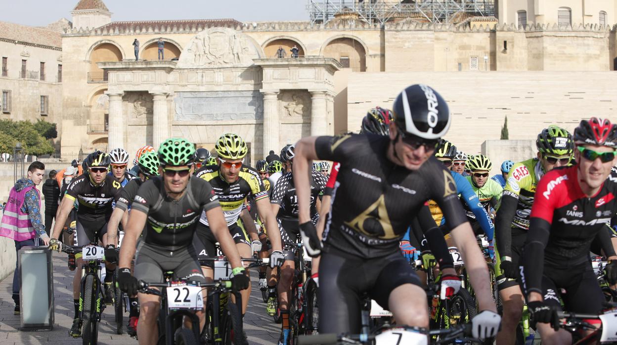 Los ciclistas salen por el Puente Romano en Córdoba