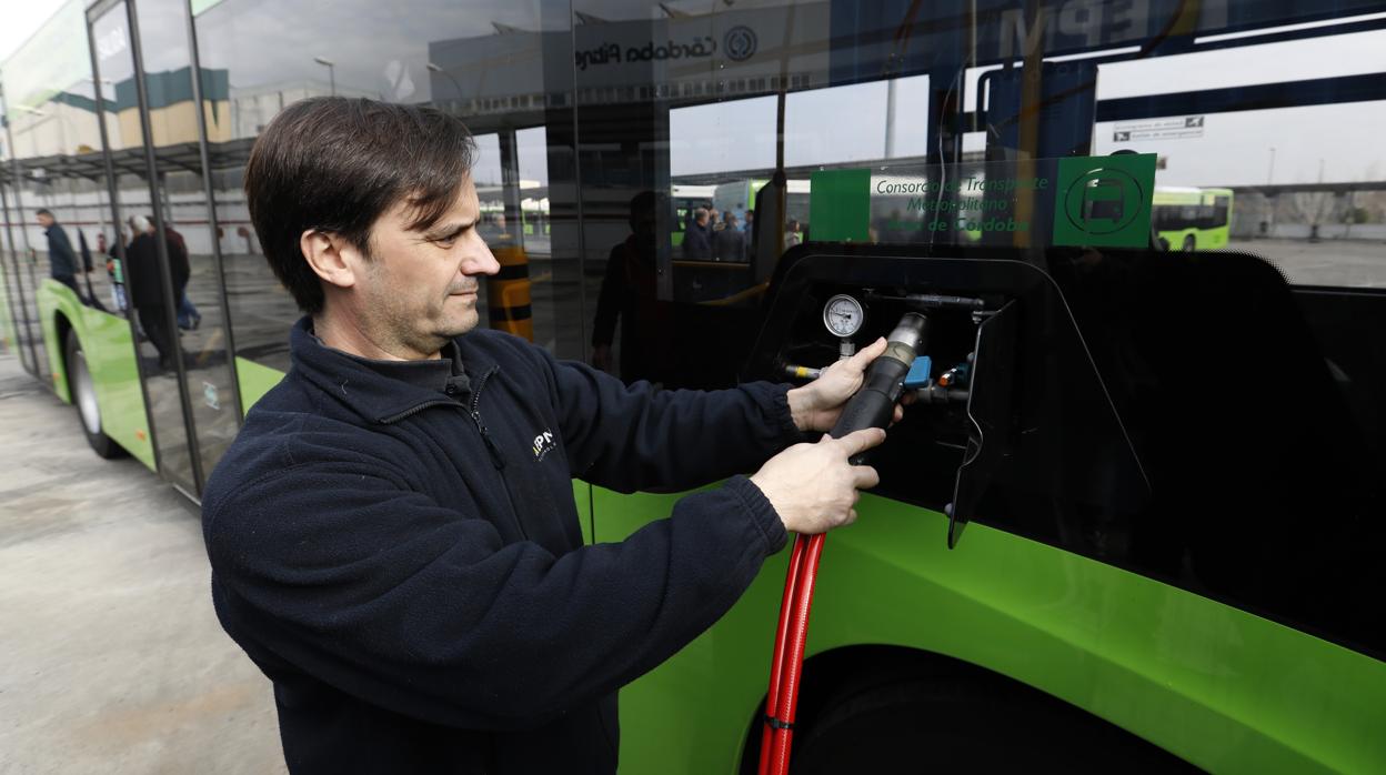 Un trabajador de Aucorsa carga en la gasinera uno de los autobuses a gas