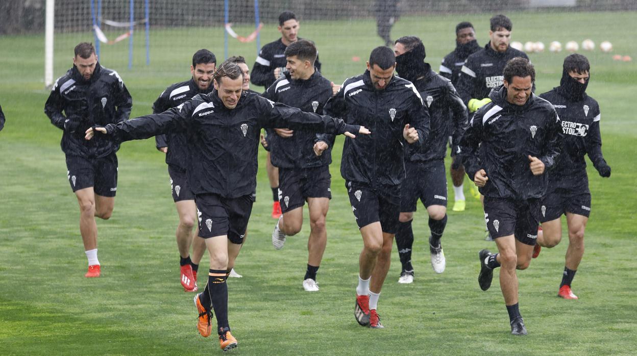 La plantilla del Córdoba CF, durante un entrenamiento bajo la lluvia