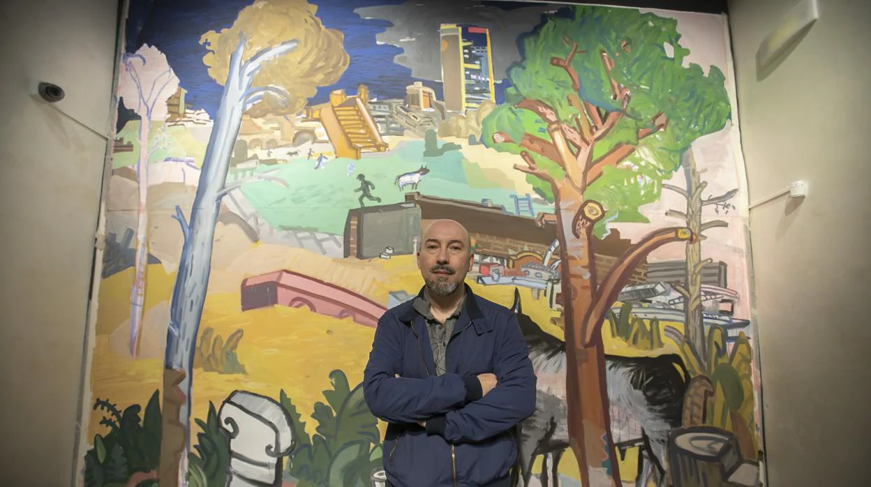 Manuel Garcés junto a su mural