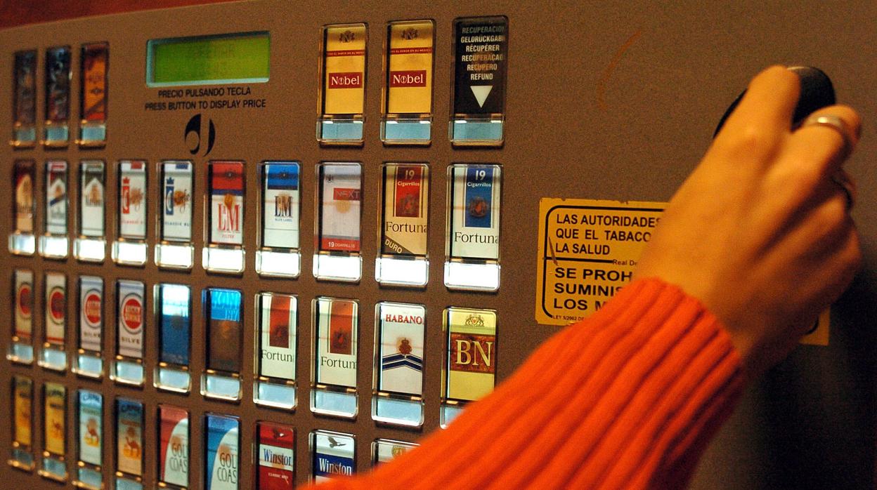 Una persona se dispone a comprar una cajetilla de cigarrillos en una máquina expendedora