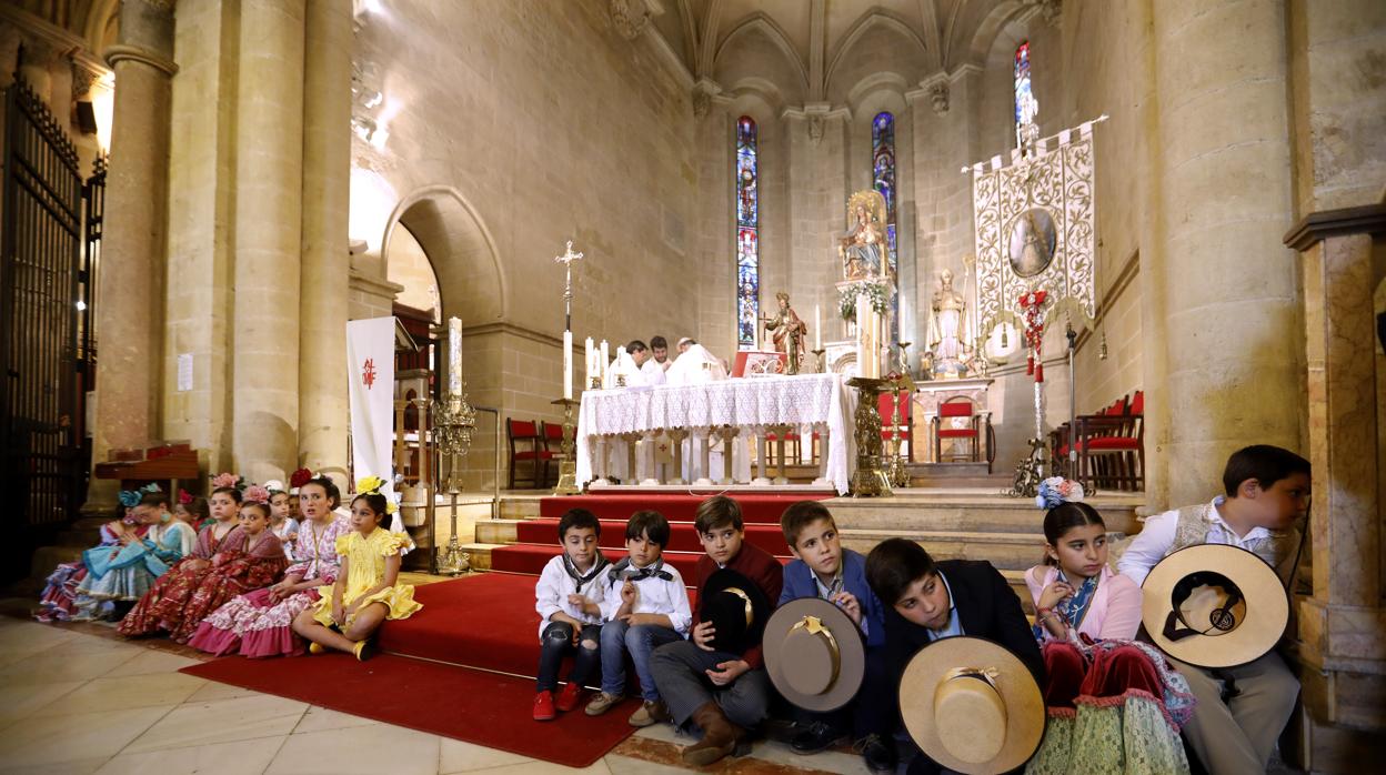 Los más pequeños de la hermandad del Rocío se sientan ante los escalones del altar de San Pablo