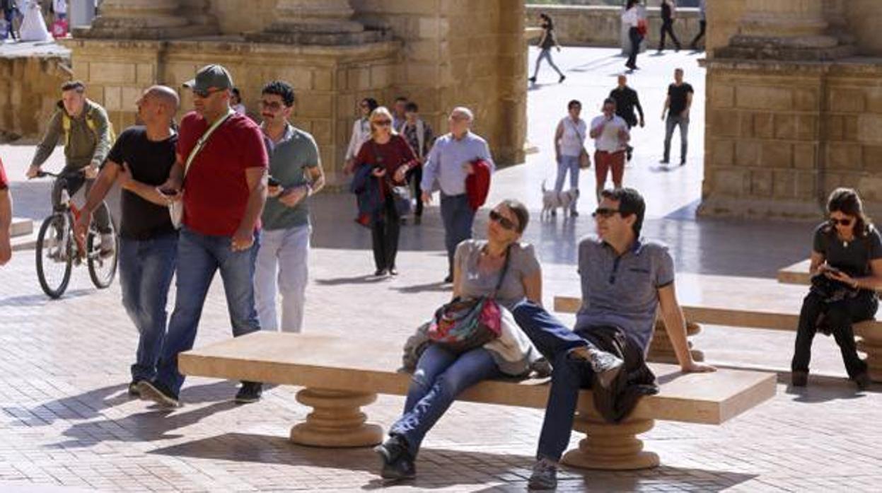 Varios turistas en la Puerta del Puente disfrutando del buen tiempo