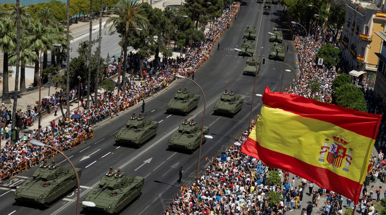 Carros de combate pasan por el Paseo de Colón de la ciudad hispalense este domingo