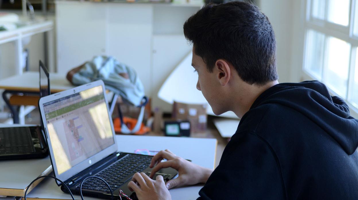Un joven con un ordenador portátil