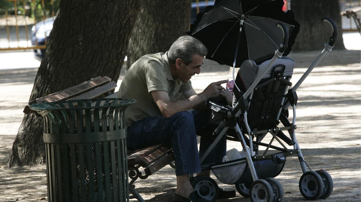 Un abuelo cuida a su nieto en un parque