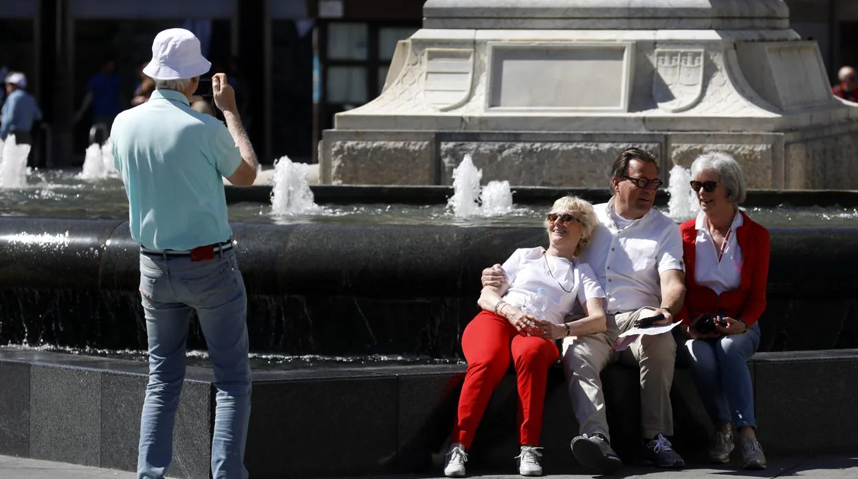 Turistas se fotografían en la fuente de Las Tendillas