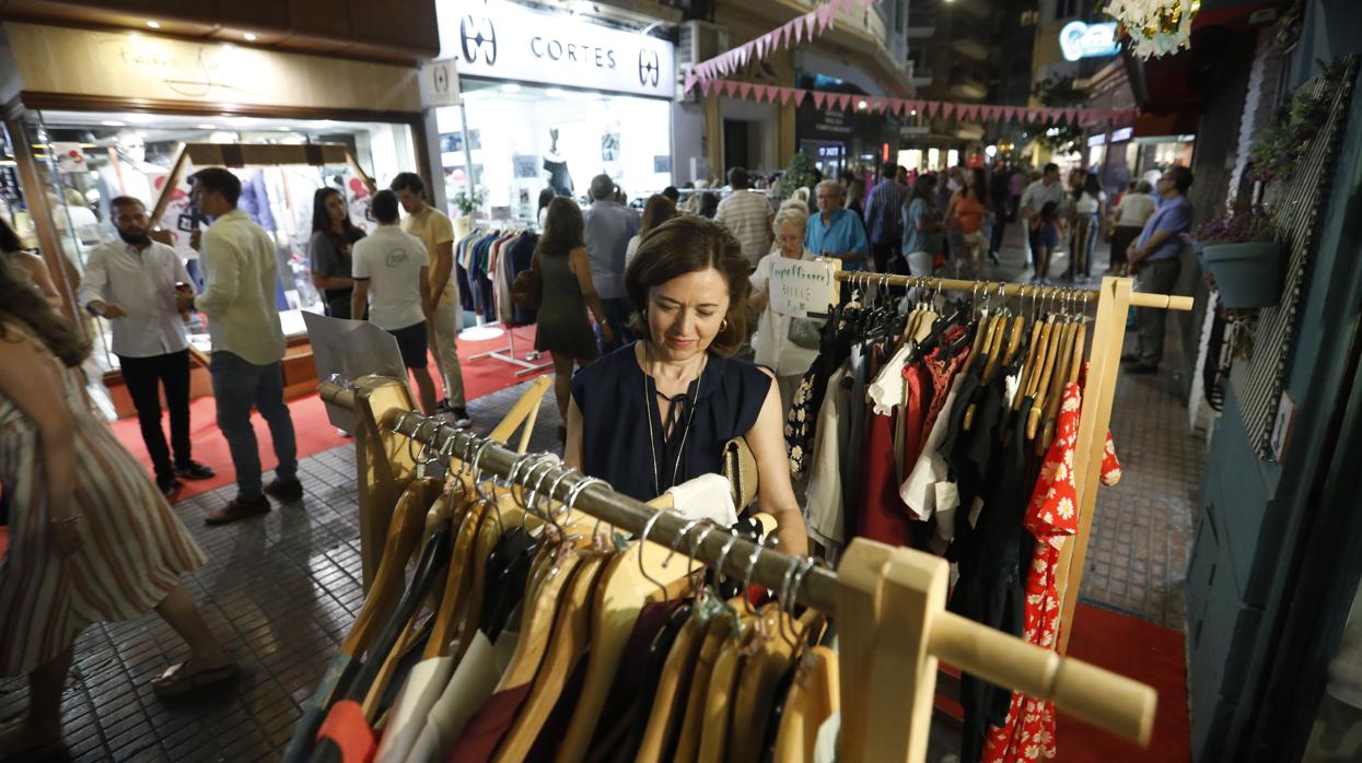 Una mujer observa la ropa de una de las tiendas de la Shopping Night