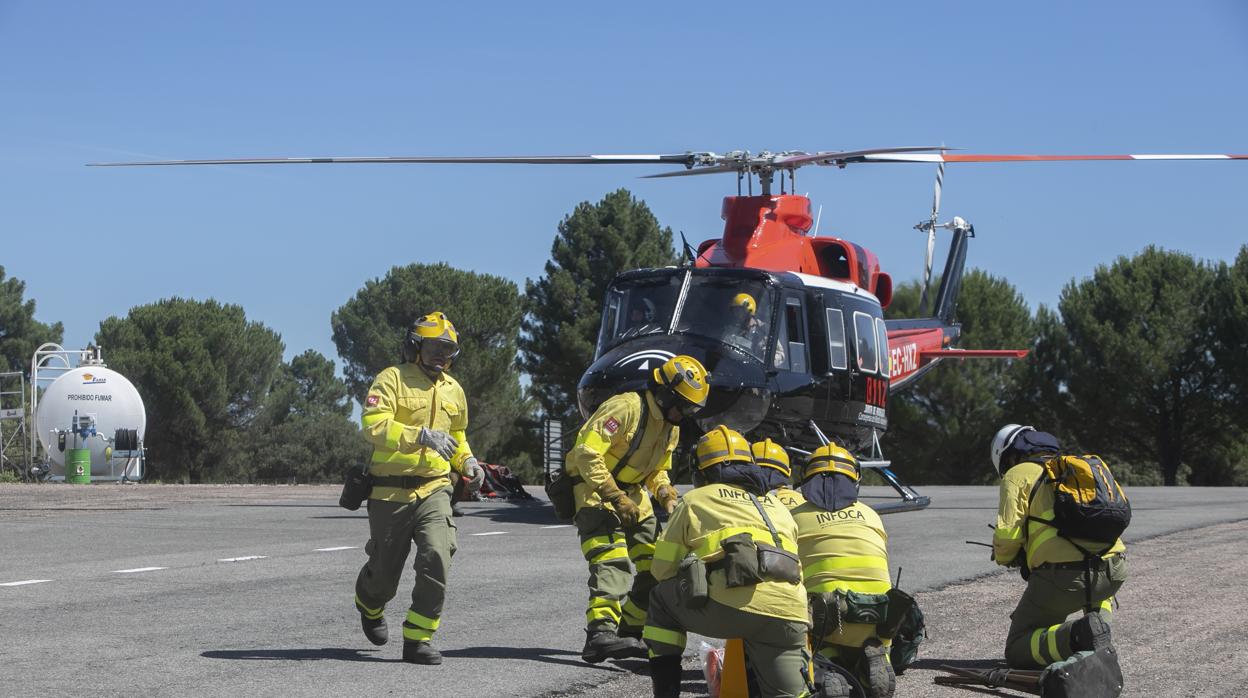 Profesionales del Infoca junto a un helicóptero en la base de Los Villares de Córdoba