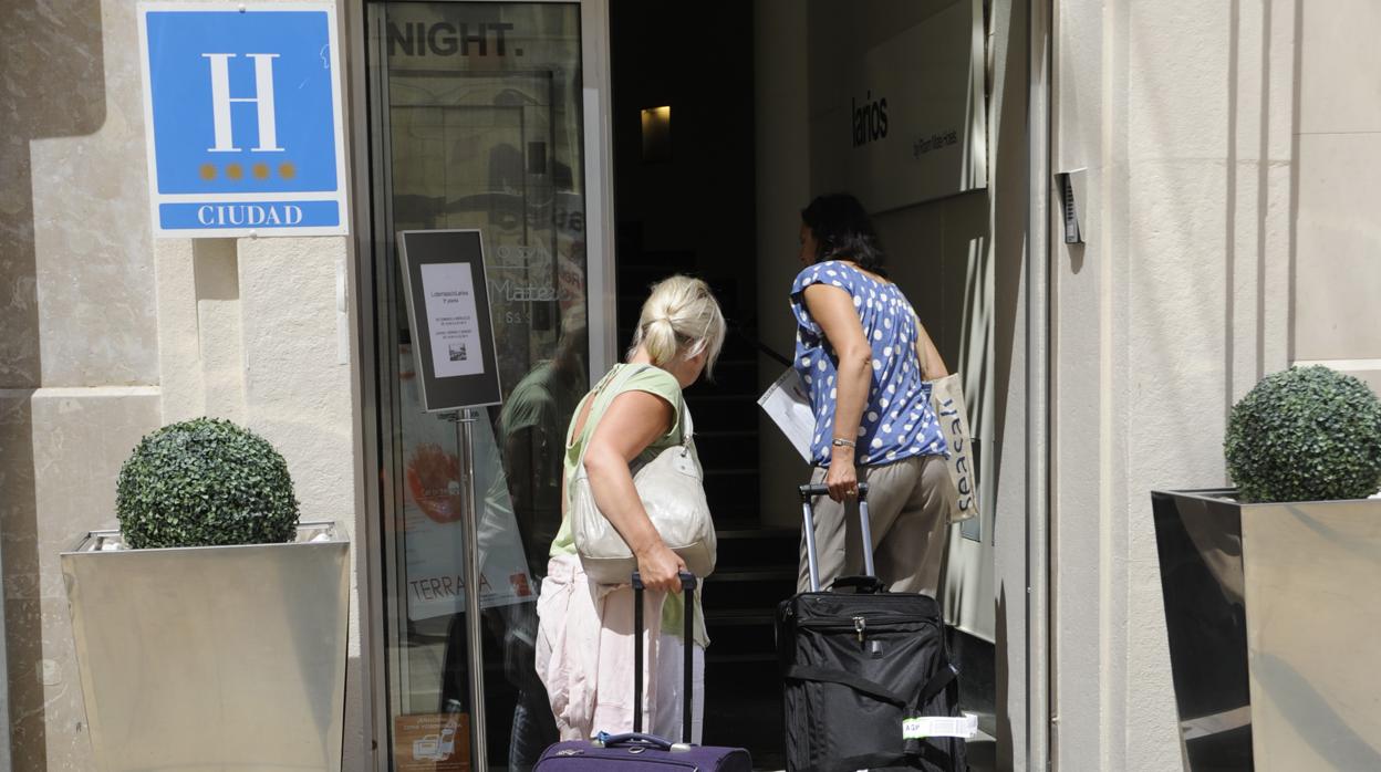 Una pareja de turistas acceden a un hotel de Málaga capital.