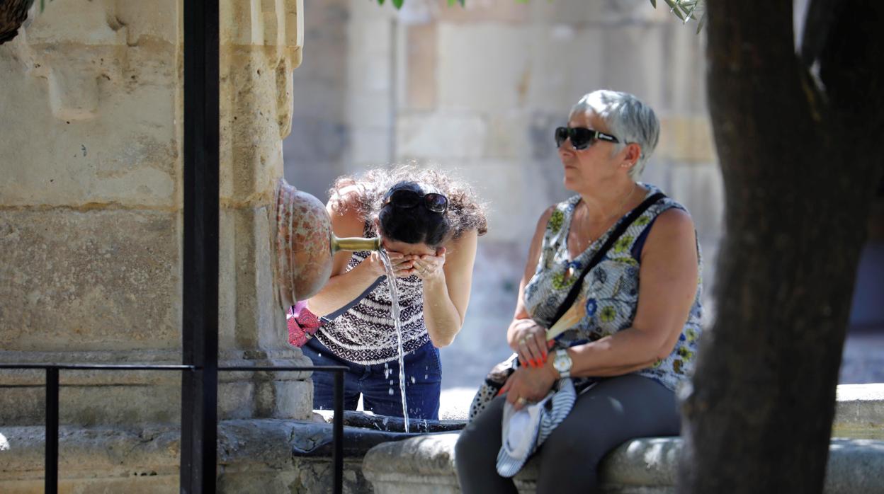 Turistas refrescándose en el Patio de los Naranjos durante la última ola de calor