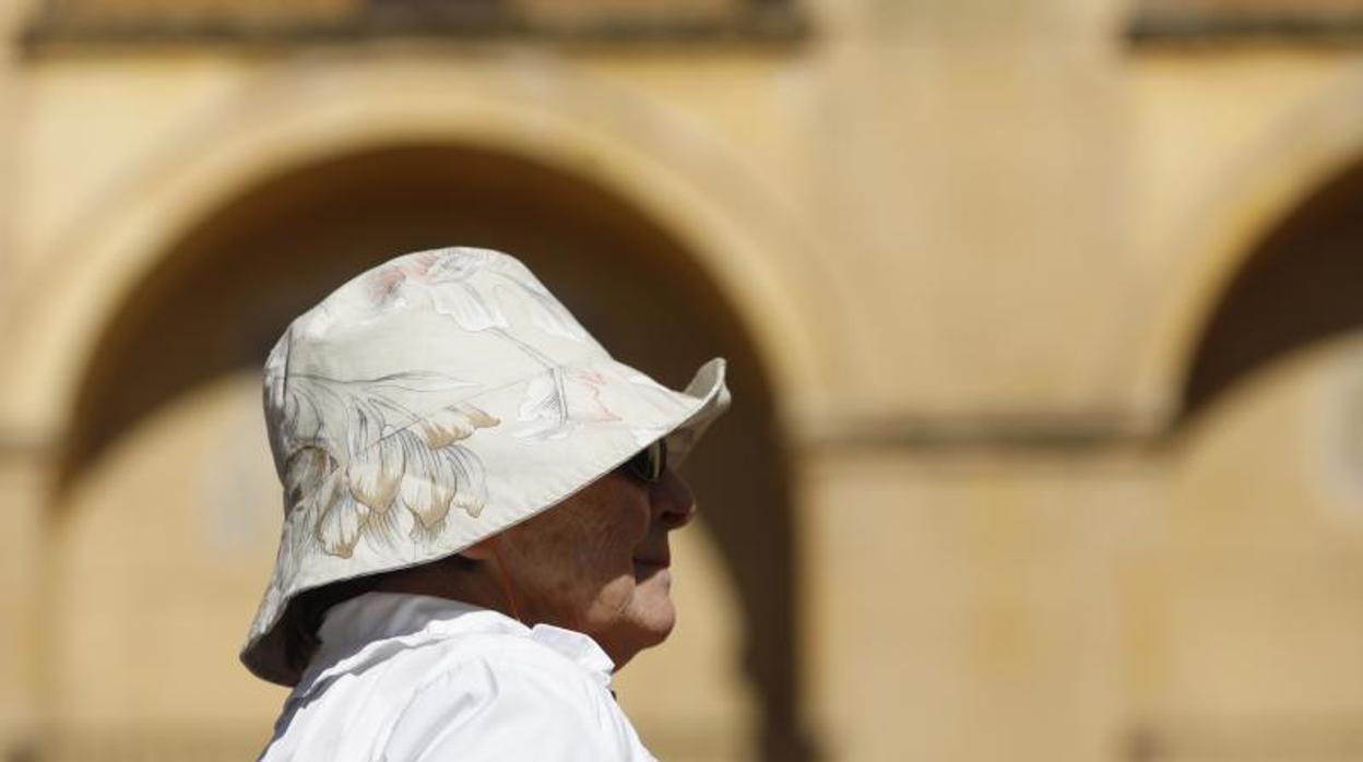 Una turista enfundada en un sombrero a pleno sol en Córdoba