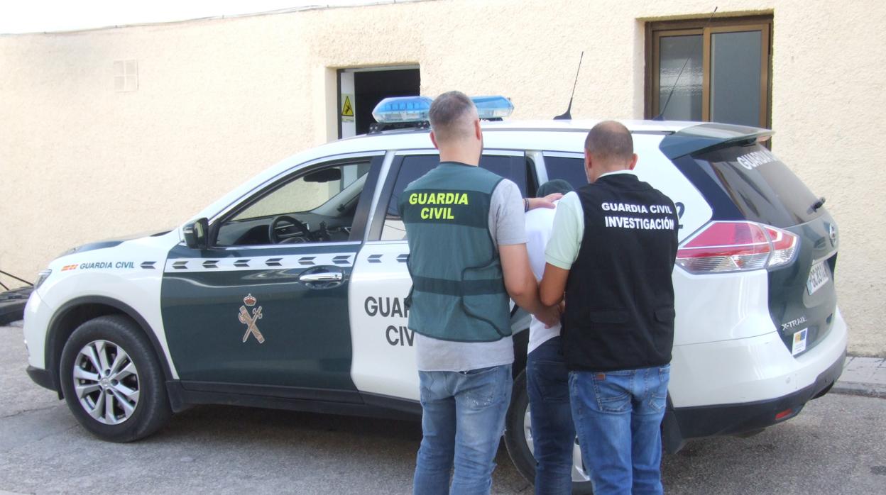 Agentes de la Guardia Civil llevan detenido a uno de los presuntos atracadores