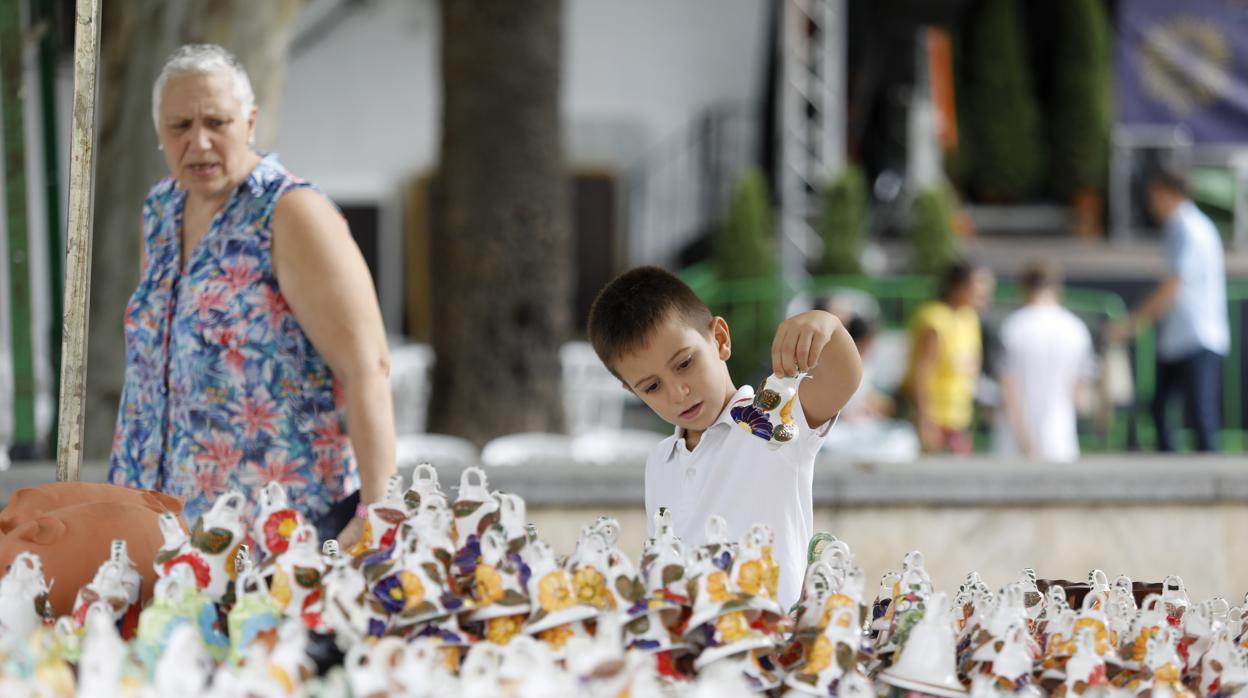 Un niño sujeta una campanita de la Velá