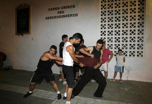 Costaleros fajándose durante un ensayo en Córdoba