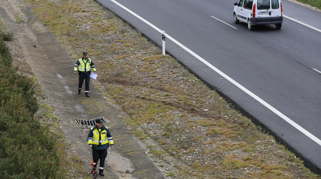 Dos guardias civiles inspeccionan la zona de un accidente