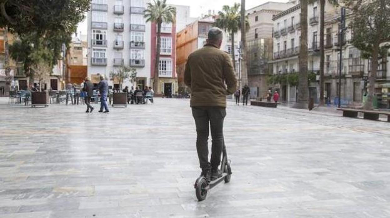 Usuario de patinete circulando por una ciudad