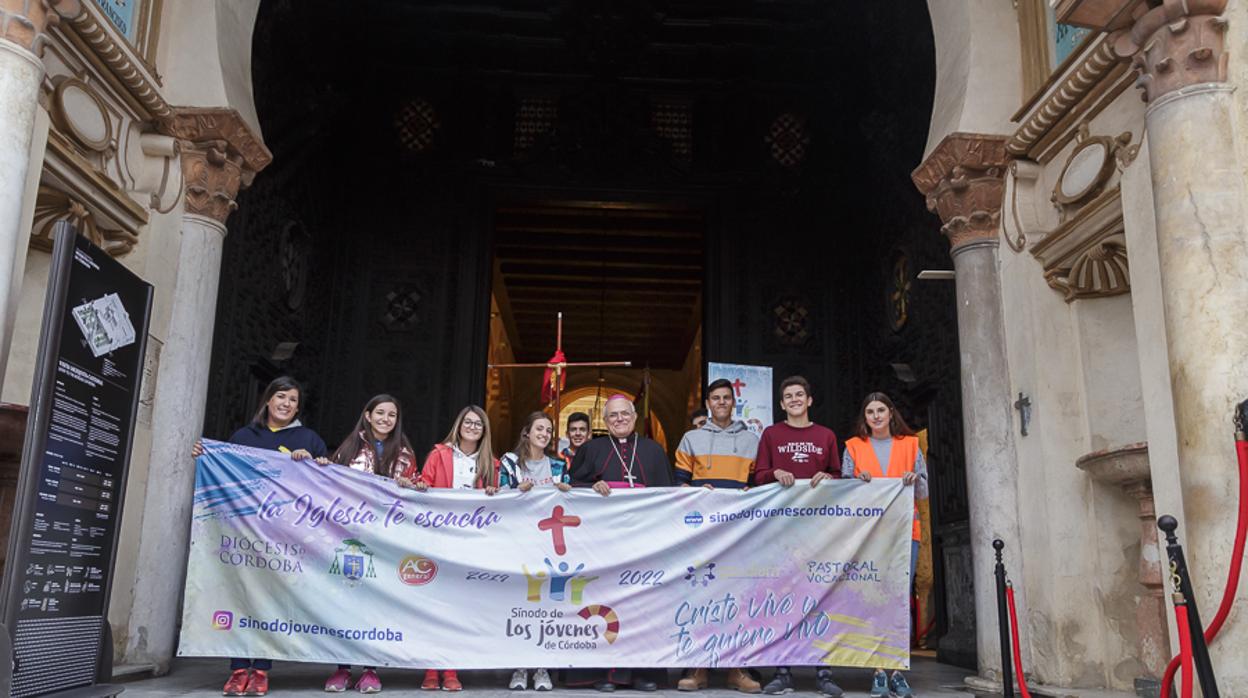 El obispo junto a varios jóvenes que portan una pancarta sobre la peregrinación