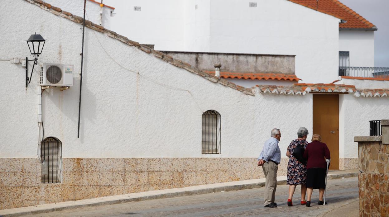 Tres personas mayores caminan por una calle de Los Blázquez