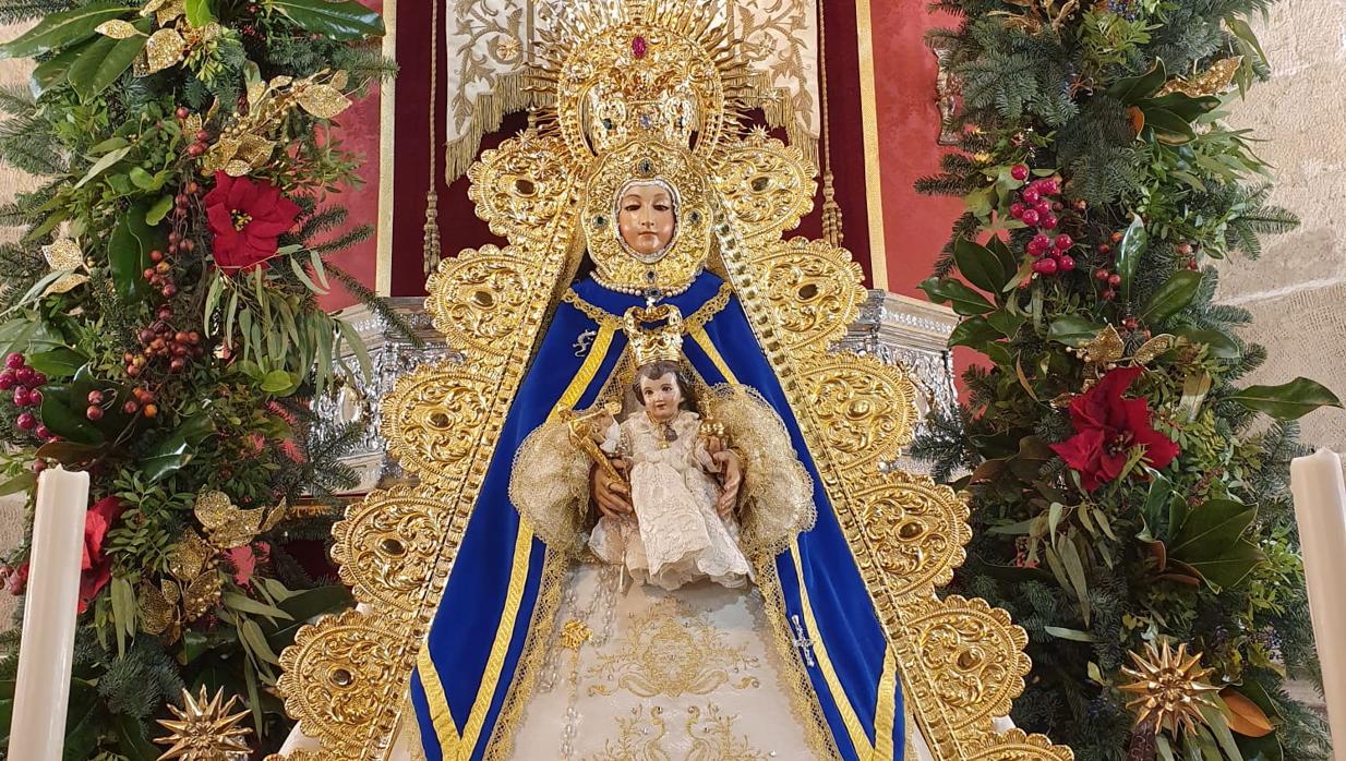 La Virgen del Rocío, ataviada como en el Simpecado expuesto al fondo