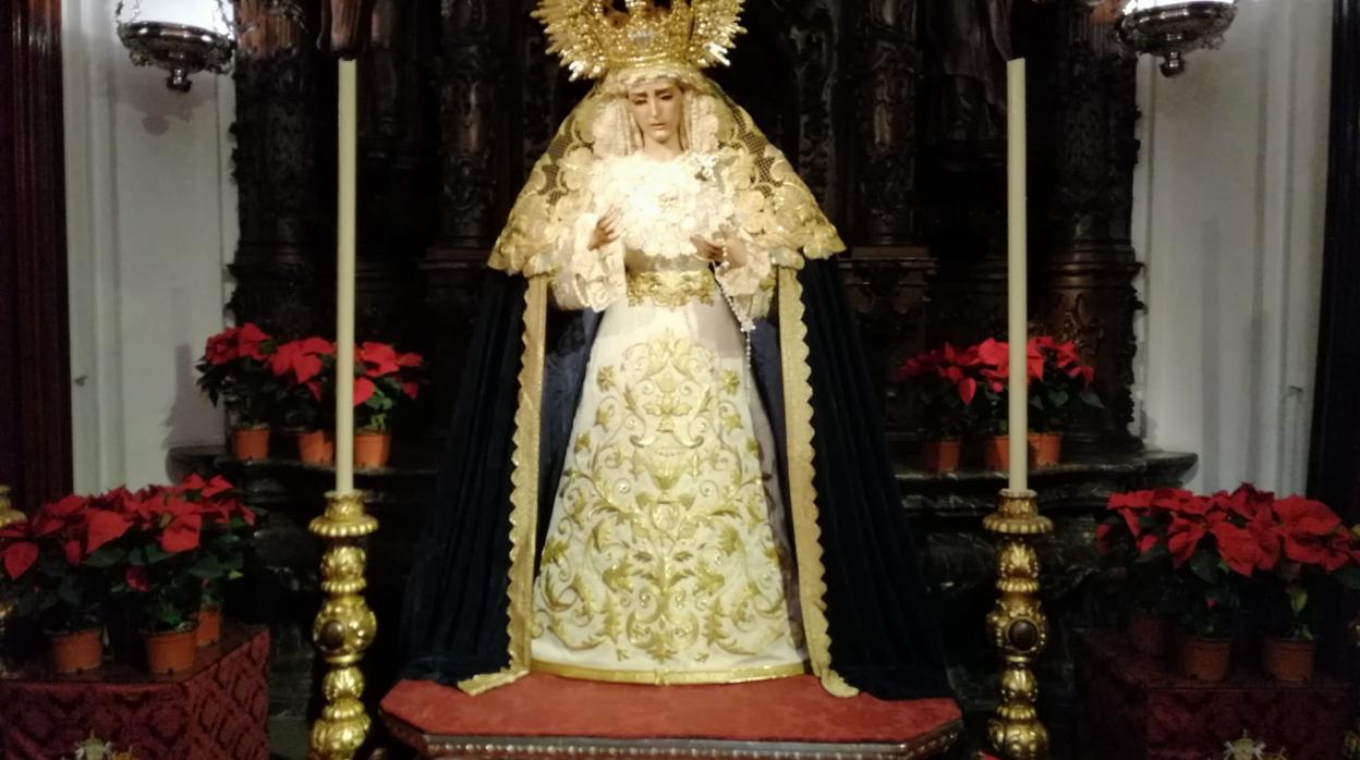 Nuestra Señora Reina de los Mártires, rodeada de flores de pascua en su capitall de San Hipólito