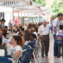 Un hombre camina entre veladores