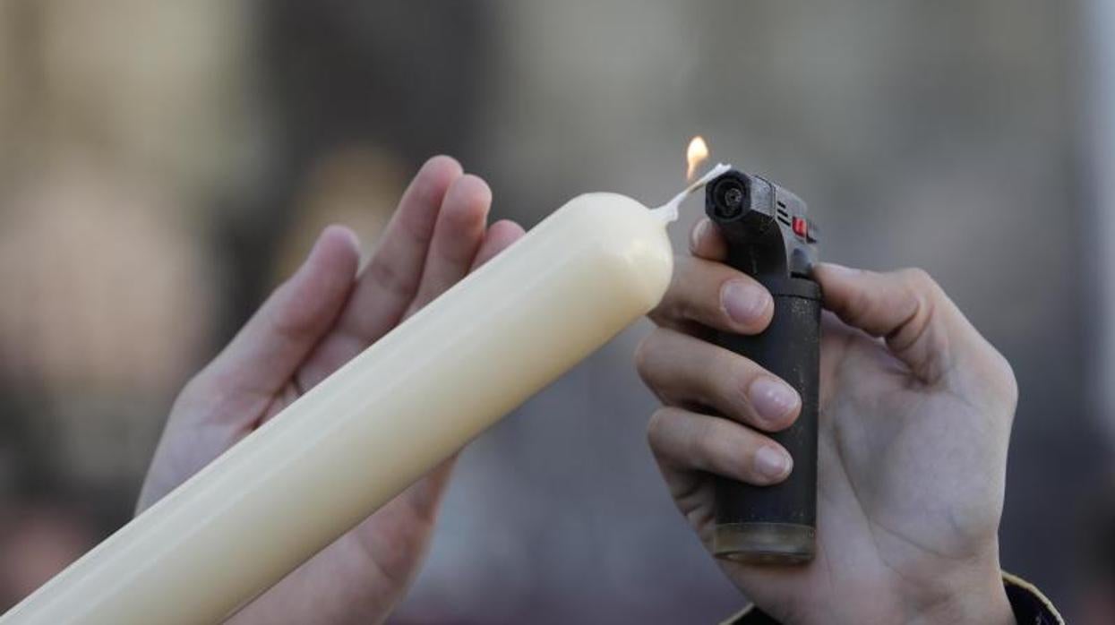 Encendido de una vela durante una procesión en Córdoba en la Semana Santa de 2019