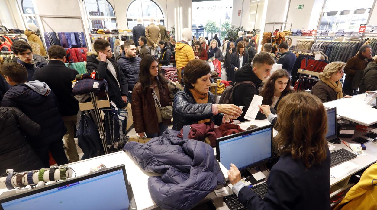 Una clienta rec ibe un ticket de la dependienta en una tienda del centro, el primer día de rebajas