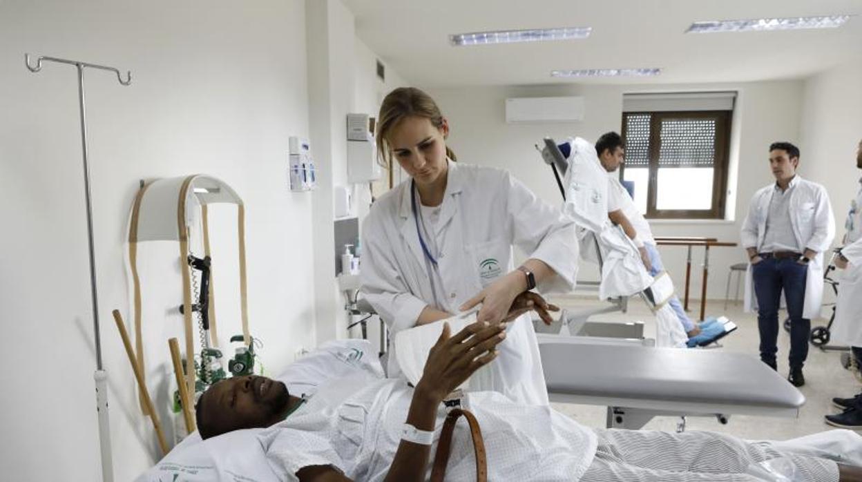 Dos pacientes en camillas adaptadas realizan ejercicios en la sala de Neurorehabilitación