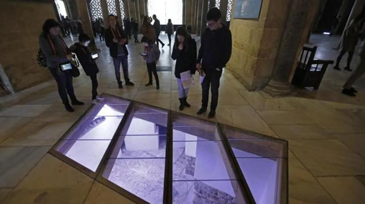 Unos turistas observan los restos hallados bajo la Mezquita-Catedral