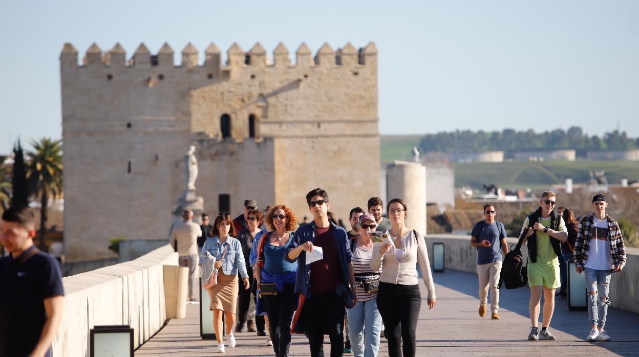 Turistas pasean por el Puente Romano en un primaveral día de febrero