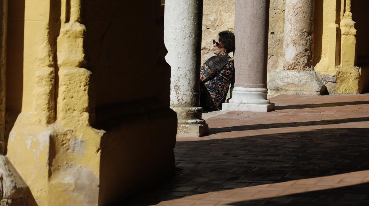 Una turista reposa sobre una columna del Patio de los Naranjos de Córdoba