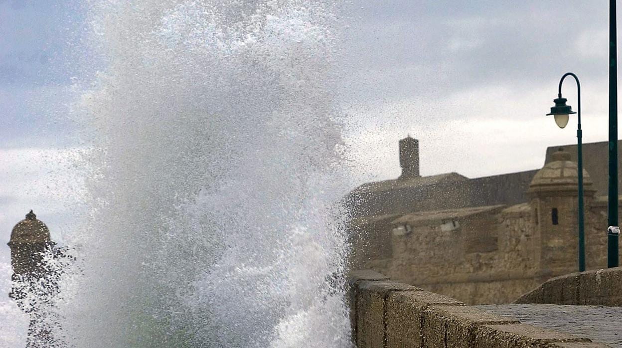 Una gran ola rompe contra el castillo de San Sebastián de Cádiz
