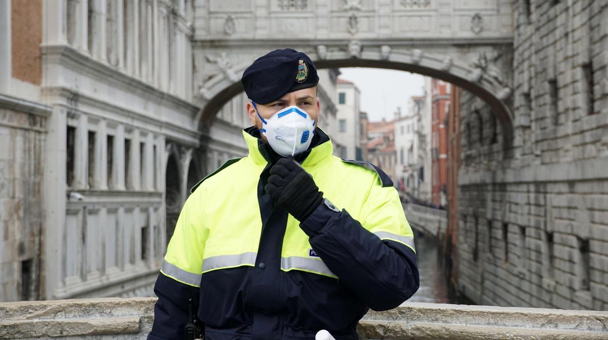 Un policía del norte de Italia se cubre con una mascarilla